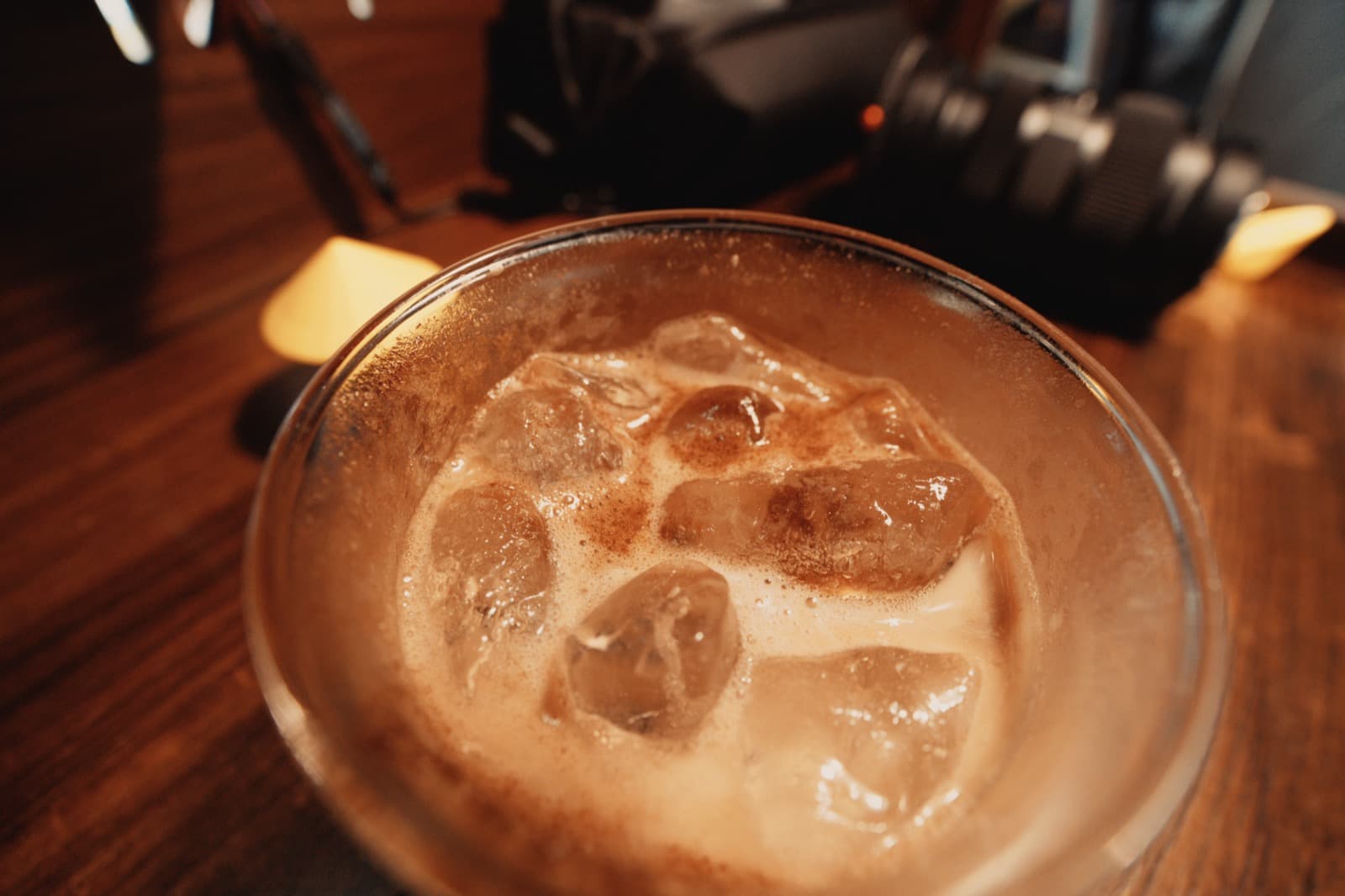 Iced coffee close-up with camera gear in the background